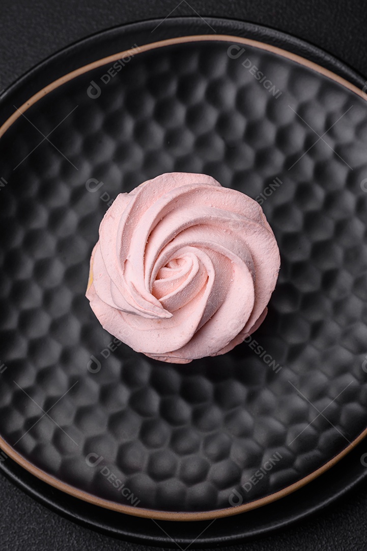 Delicioso marshmallow colorido doce em um fundo escuro de concreto. Doces saudáveis ​​para a mesa de jantar