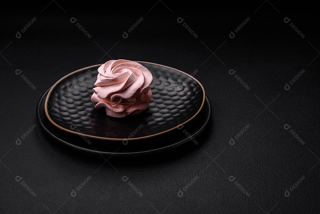 Delicioso marshmallow colorido doce em um fundo escuro de concreto. Doces saudáveis ​​para a mesa de jantar