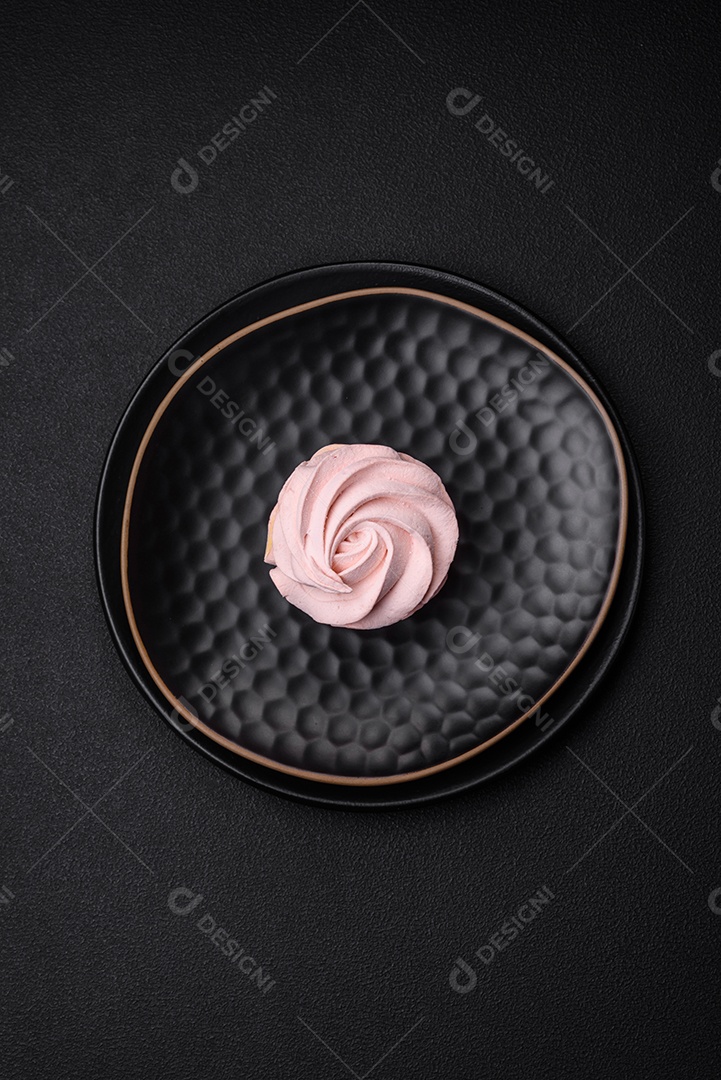 Delicioso marshmallow colorido doce em um fundo escuro de concreto. Doces saudáveis ​​para a mesa de jantar