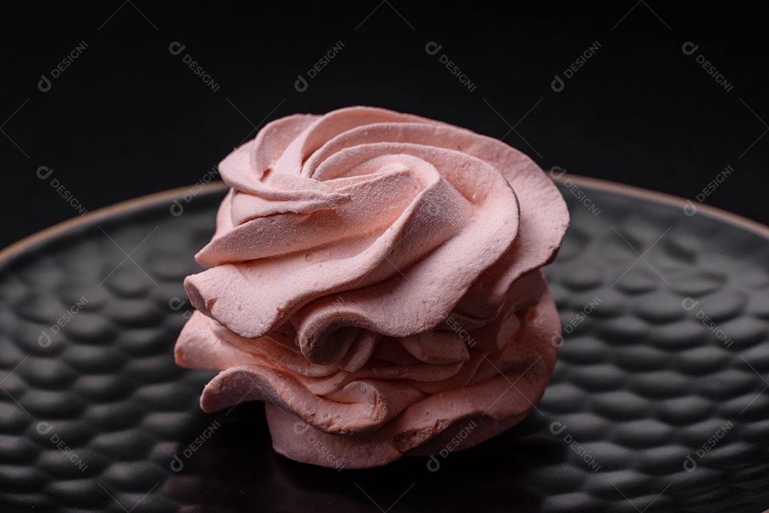 Delicioso marshmallow colorido doce em um fundo escuro de concreto. Doces saudáveis ​​para a mesa de jantar