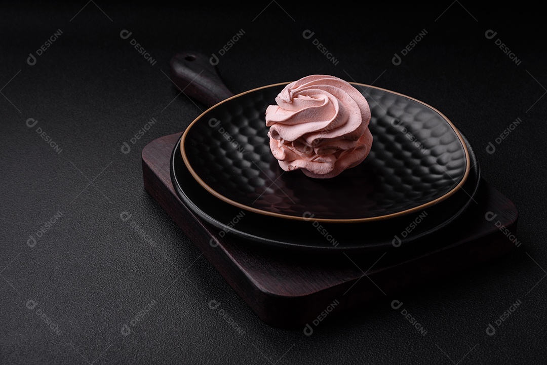 Delicioso marshmallow colorido doce em um fundo escuro de concreto. Doces saudáveis ​​para a mesa de jantar