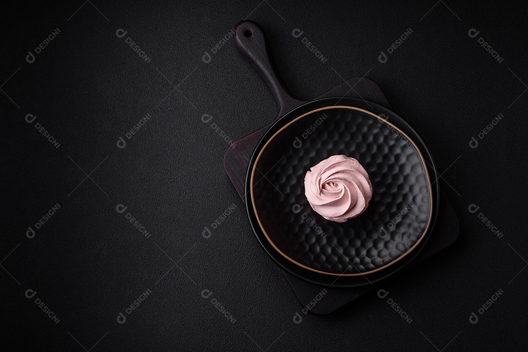 Delicioso marshmallow colorido doce em um fundo escuro de concreto. Doces saudáveis ​​para a mesa de jantar