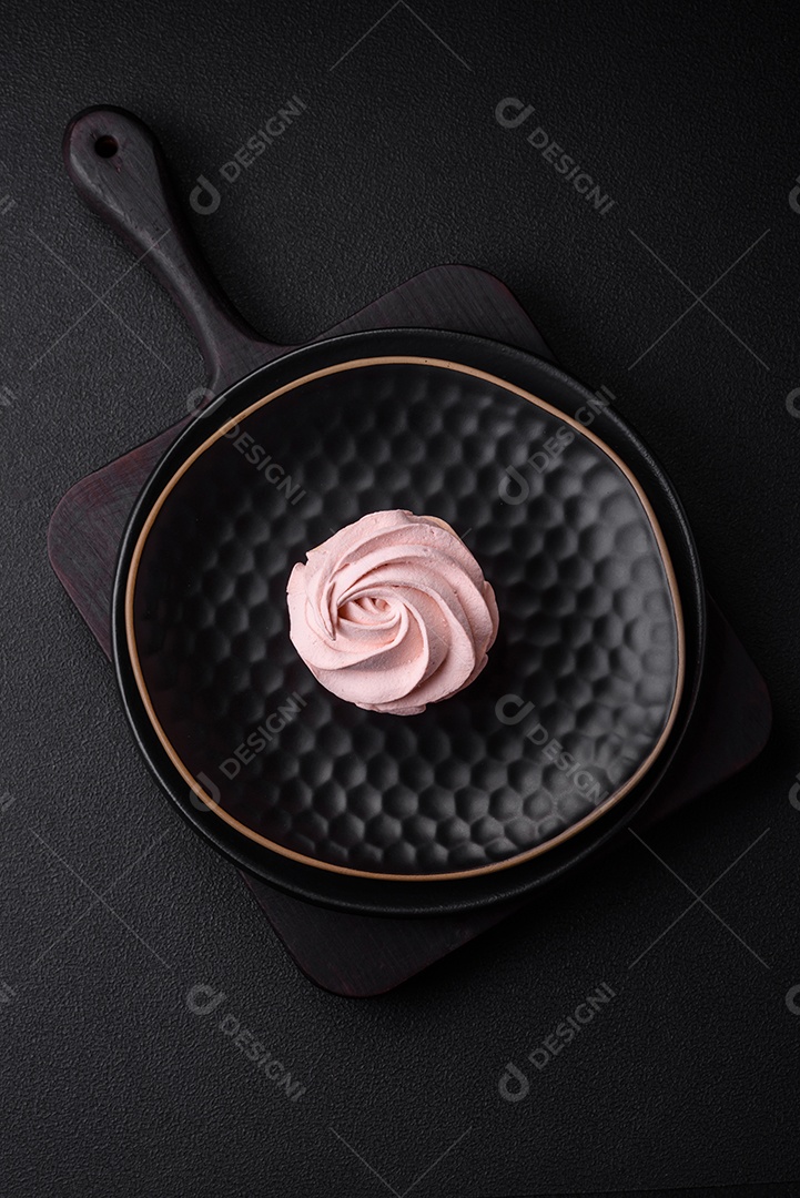 Delicioso marshmallow colorido doce em um fundo escuro de concreto. Doces saudáveis ​​para a mesa de jantar