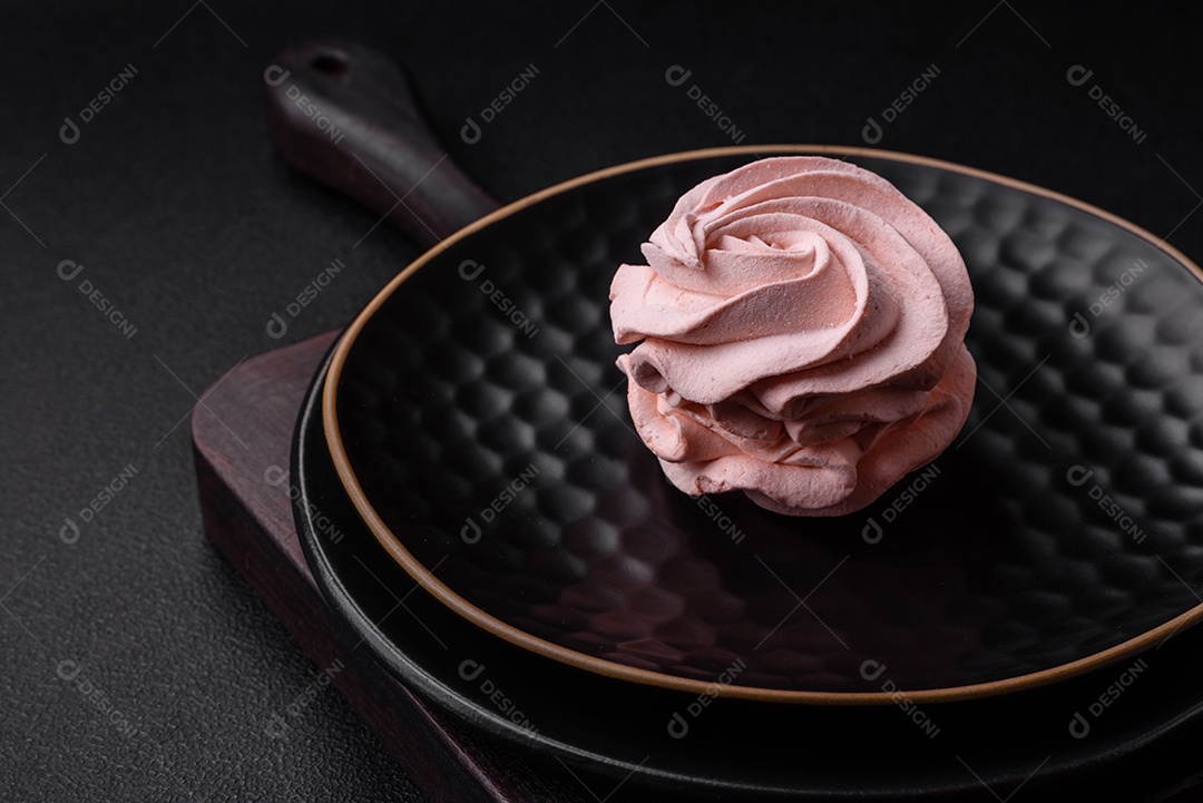 Delicioso marshmallow colorido doce em um fundo escuro de concreto. Doces saudáveis ​​para a mesa de jantar