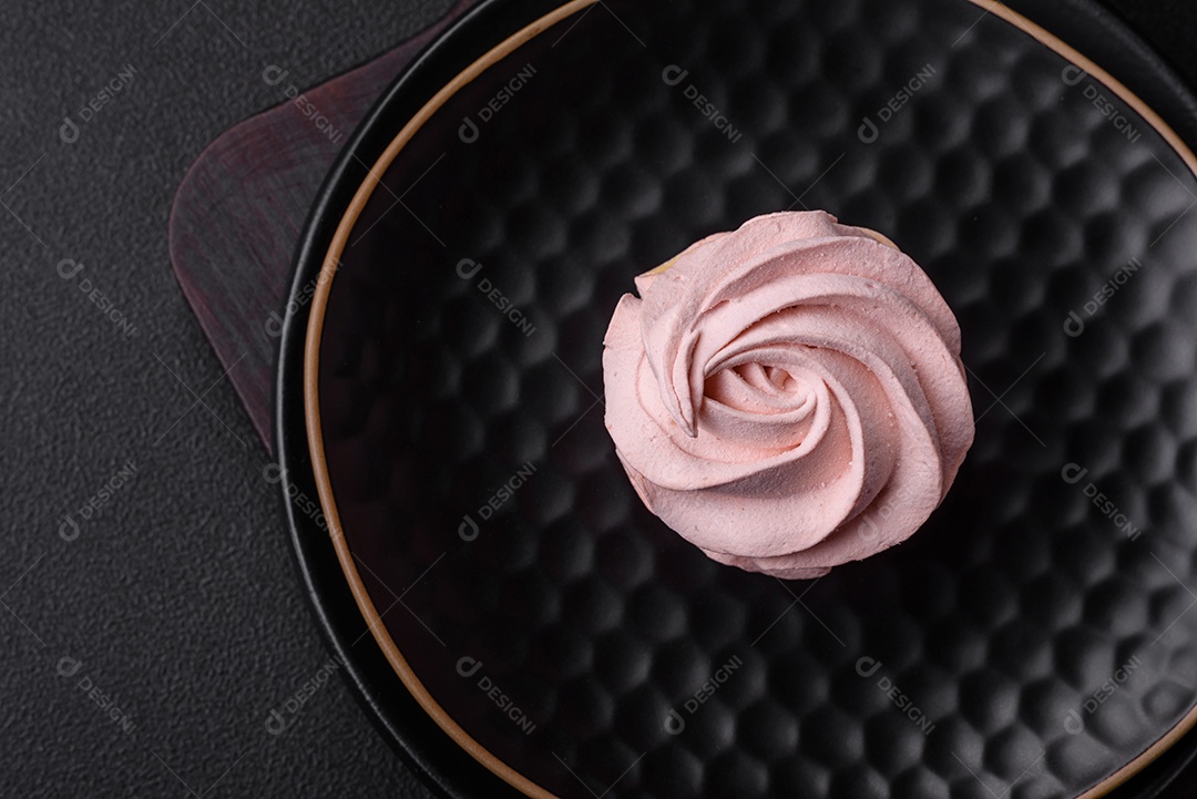 Delicioso marshmallow colorido doce em um fundo escuro de concreto. Doces saudáveis ​​para a mesa de jantar