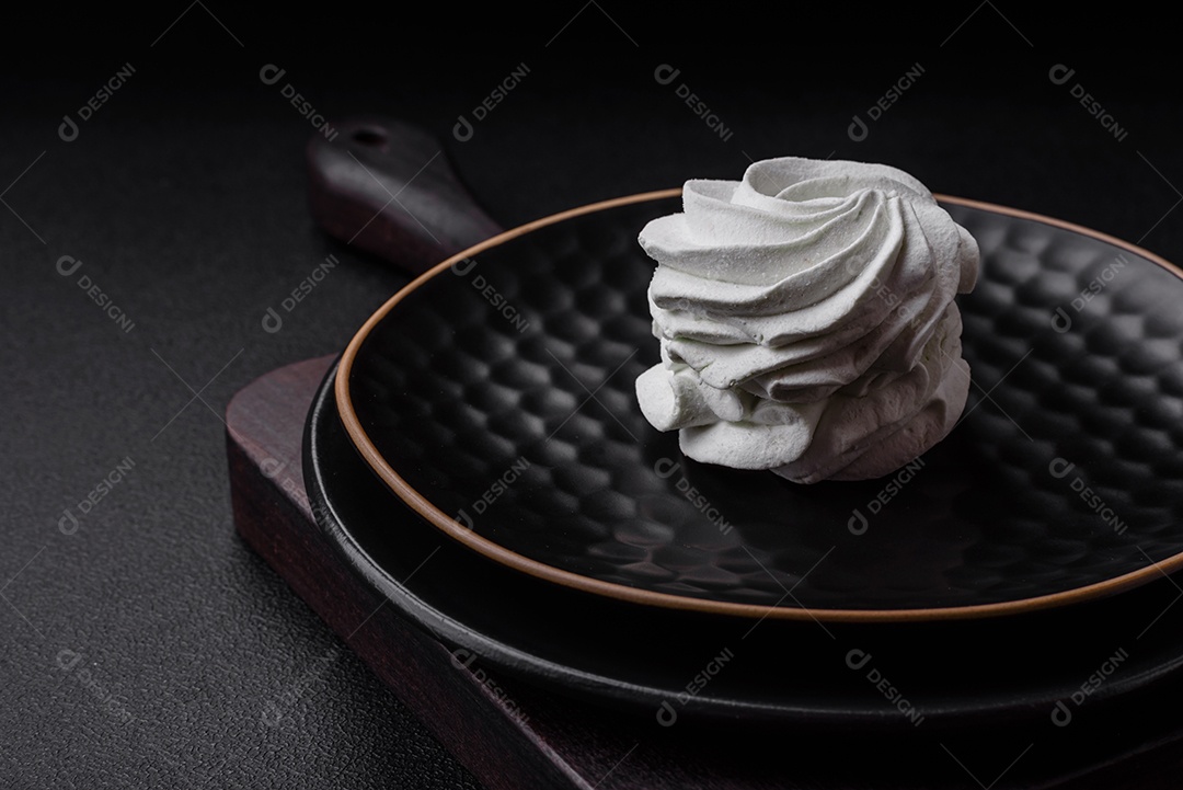 Delicioso marshmallow colorido doce em um fundo escuro de concreto. Doces saudáveis ​​para a mesa de jantar