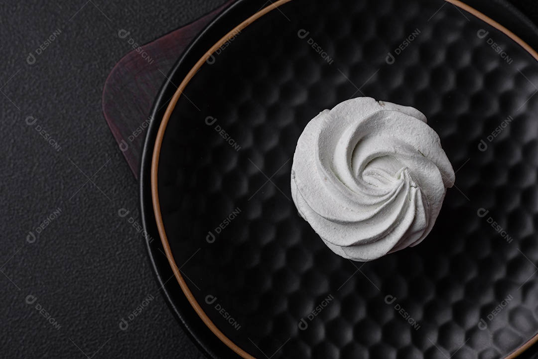 Delicioso marshmallow colorido doce em um fundo escuro de concreto. Doces saudáveis ​​para a mesa de jantar