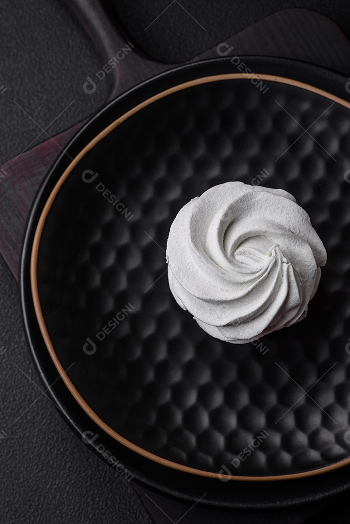 Delicioso marshmallow colorido doce em um fundo escuro de concreto. Doces saudáveis ​​para a mesa de jantar