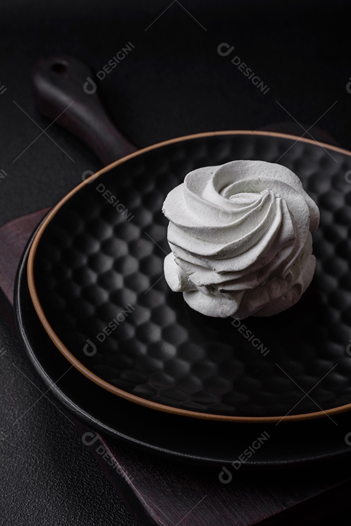 Delicioso marshmallow colorido doce em um fundo escuro de concreto. Doces saudáveis ​​para a mesa de jantar