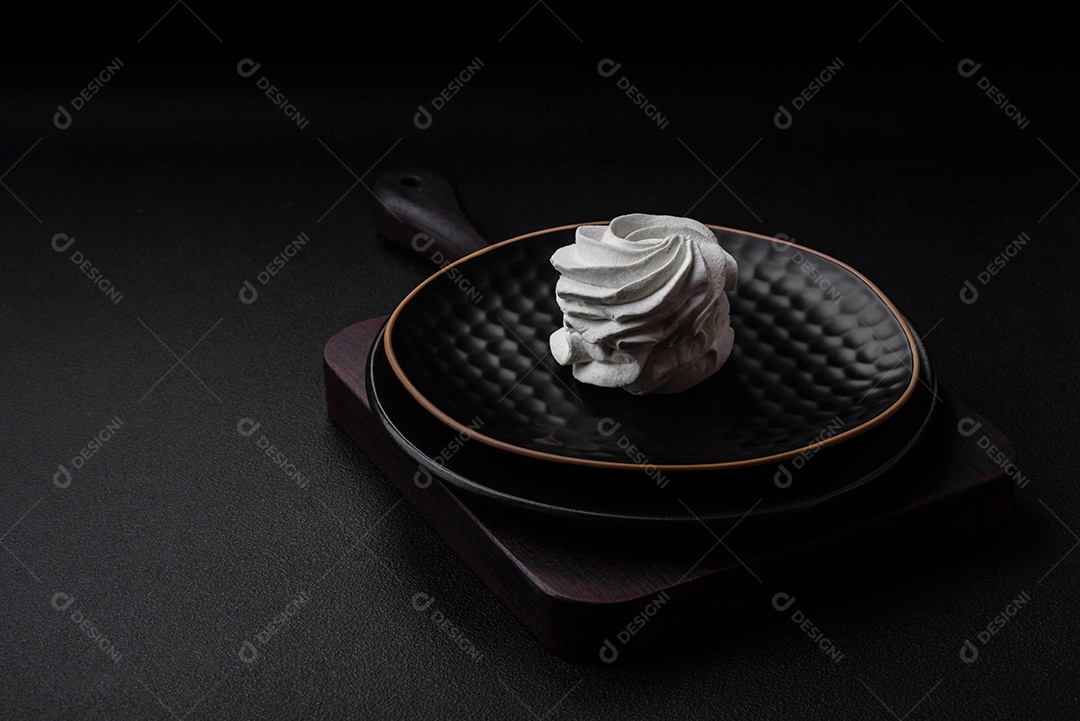 Delicioso marshmallow colorido doce em um fundo escuro de concreto. Doces saudáveis ​​para a mesa de jantar