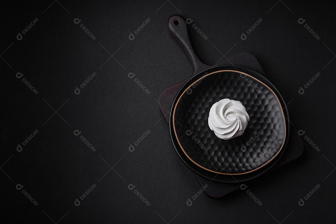 Delicioso marshmallow colorido doce em um fundo escuro de concreto. Doces saudáveis ​​para a mesa de jantar