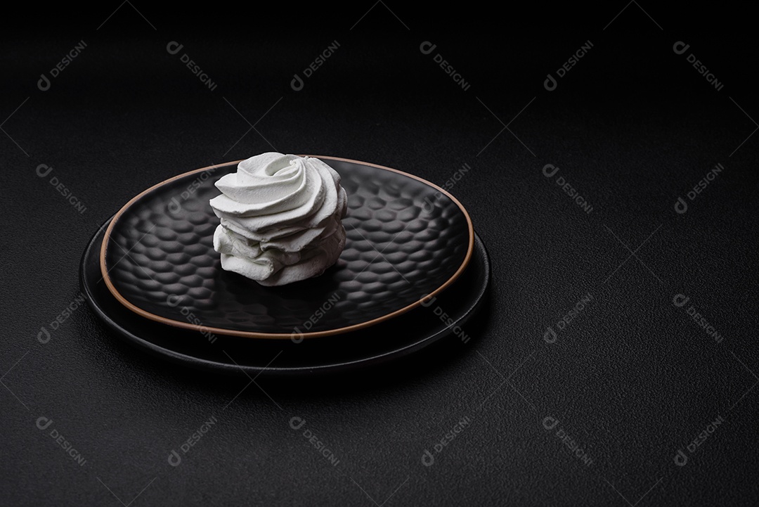 Delicioso marshmallow colorido doce em um fundo escuro de concreto. Doces saudáveis ​​para a mesa de jantar