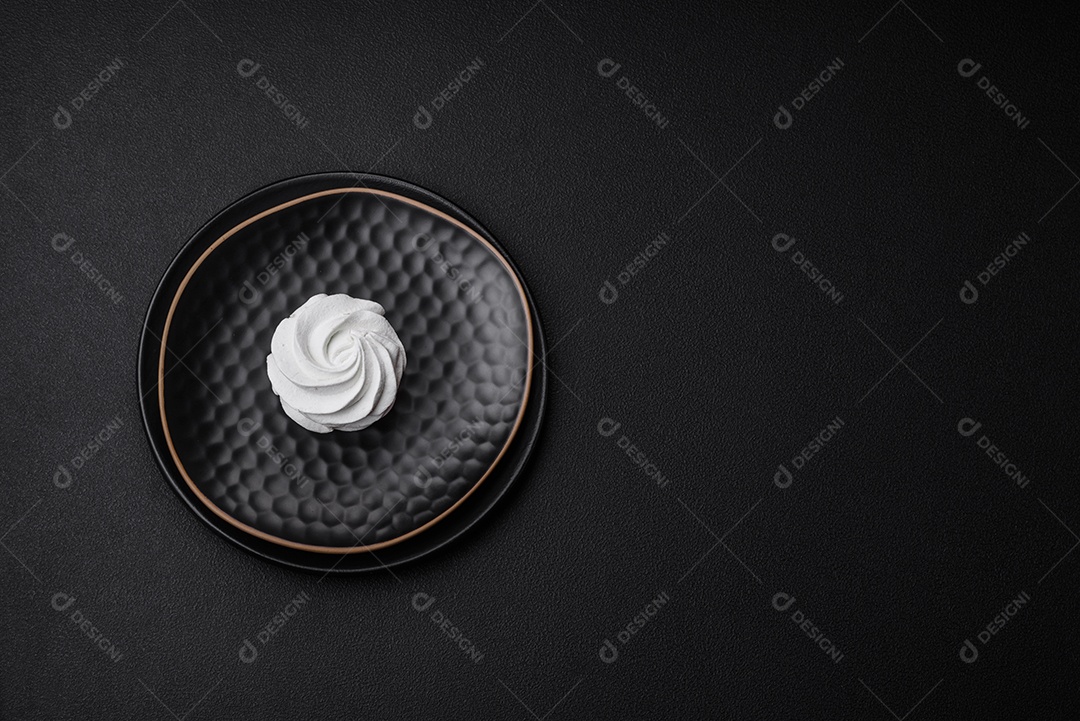 Delicioso marshmallow colorido doce em um fundo escuro de concreto. Doces saudáveis ​​para a mesa de jantar