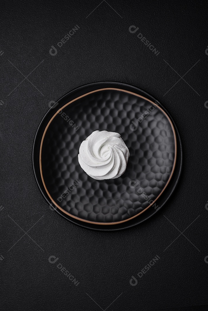 Delicioso marshmallow colorido doce em um fundo escuro de concreto. Doces saudáveis ​​para a mesa de jantar