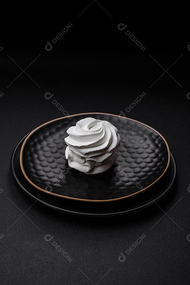 Delicioso marshmallow colorido doce em um fundo escuro de concreto. Doces saudáveis ​​para a mesa de jantar