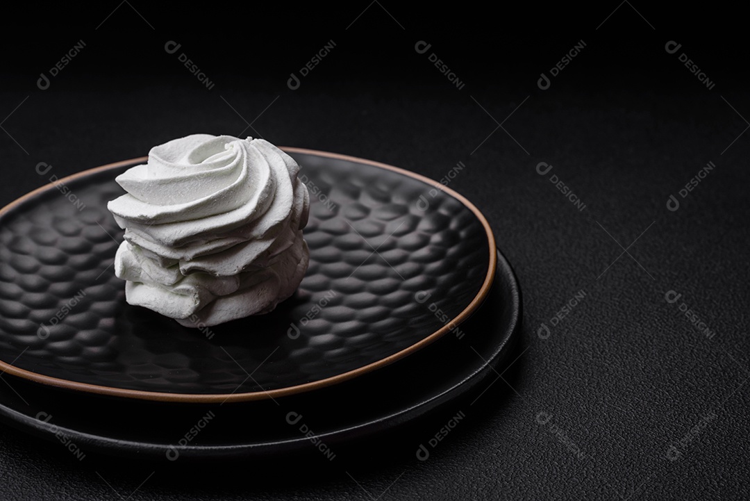 Delicioso marshmallow colorido doce em um fundo escuro de concreto. Doces saudáveis ​​para a mesa de jantar