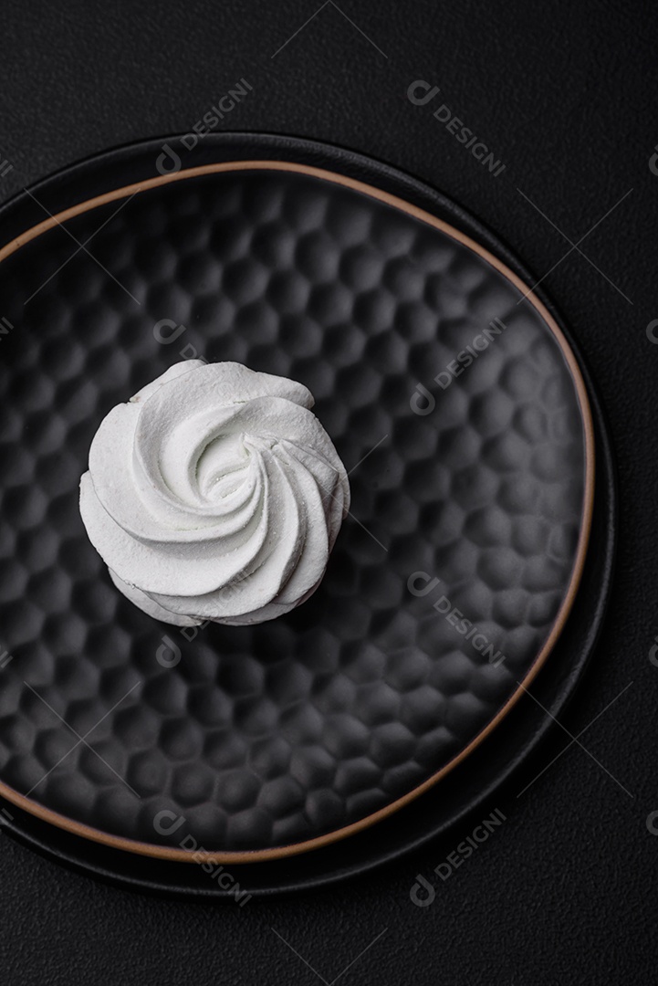 Delicioso marshmallow colorido doce em um fundo escuro de concreto. Doces saudáveis ​​para a mesa de jantar