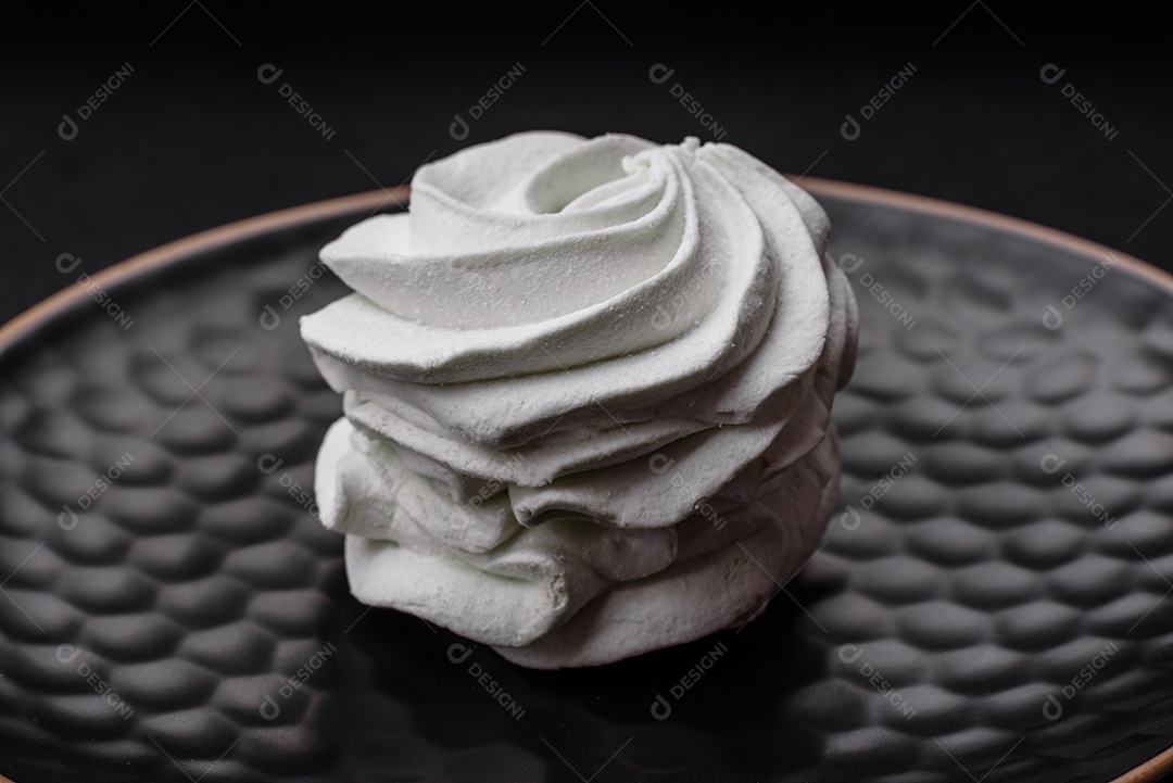 Delicioso marshmallow colorido doce em um fundo escuro de concreto. Doces saudáveis ​​para a mesa de jantar