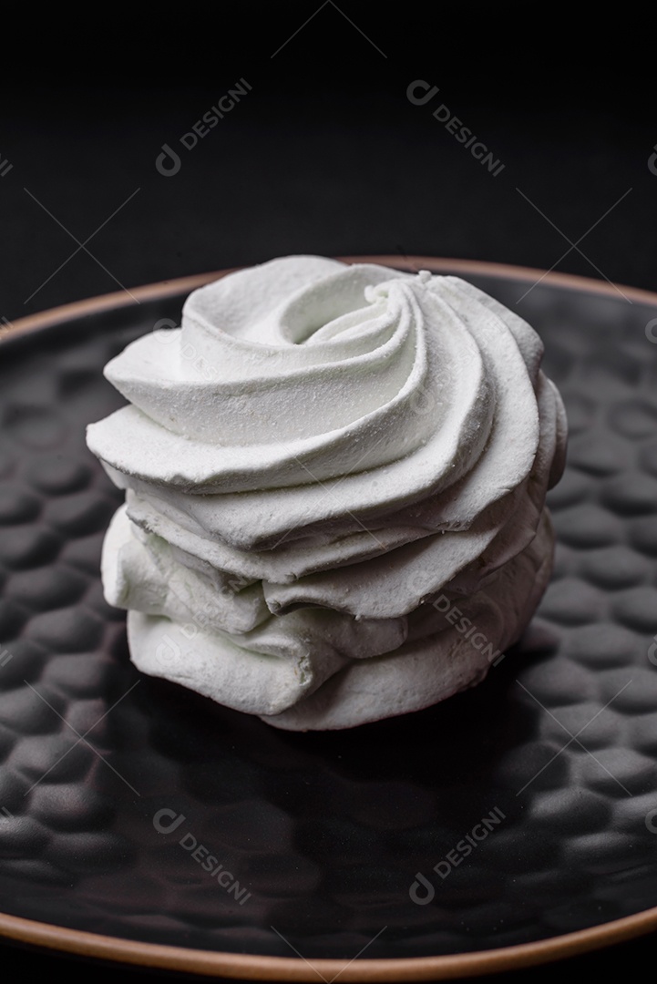 Delicioso marshmallow colorido doce em um fundo escuro de concreto. Doces saudáveis ​​para a mesa de jantar