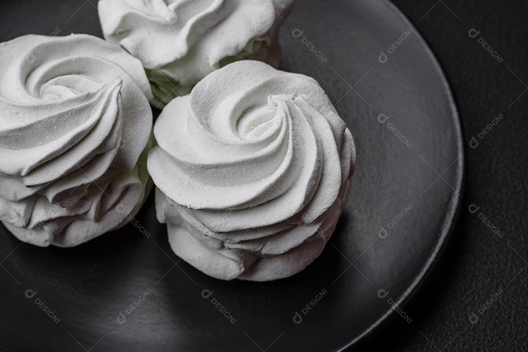 Delicioso marshmallow colorido doce em um fundo escuro de concreto. Doces saudáveis ​​para a mesa de jantar