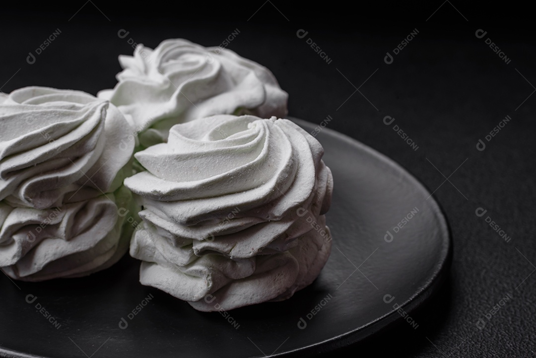 Delicioso marshmallow colorido doce em um fundo escuro de concreto. Doces saudáveis ​​para a mesa de jantar