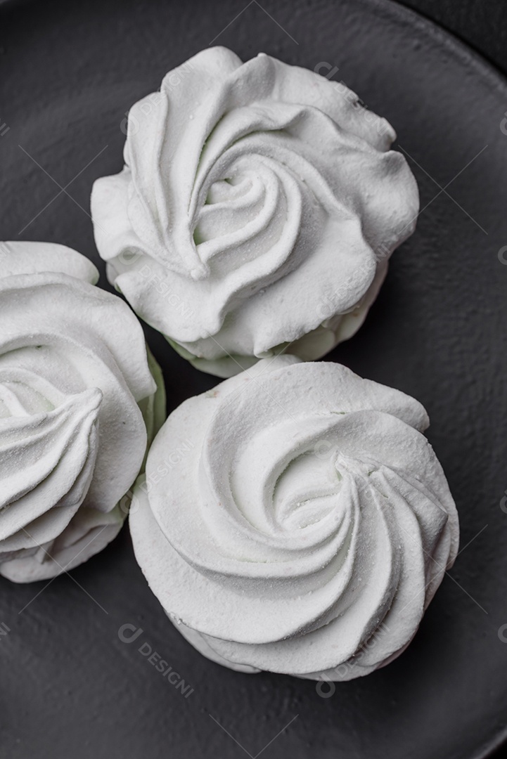 Delicioso marshmallow colorido doce em um fundo escuro de concreto. Doces saudáveis ​​para a mesa de jantar