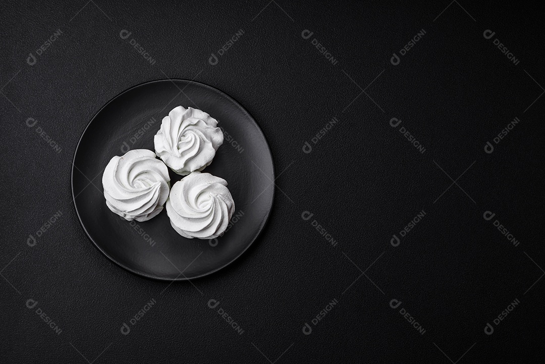 Delicioso marshmallow colorido doce em um fundo escuro de concreto. Doces saudáveis ​​para a mesa de jantar