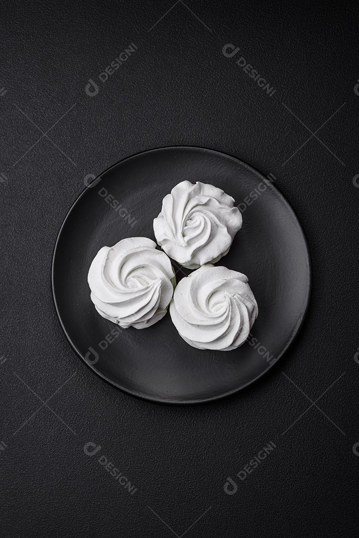 Delicioso marshmallow colorido doce em um fundo escuro de concreto. Doces saudáveis ​​para a mesa de jantar