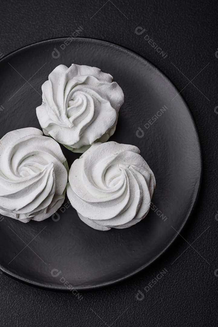 Delicioso marshmallow colorido doce em um fundo escuro de concreto. Doces saudáveis ​​para a mesa de jantar