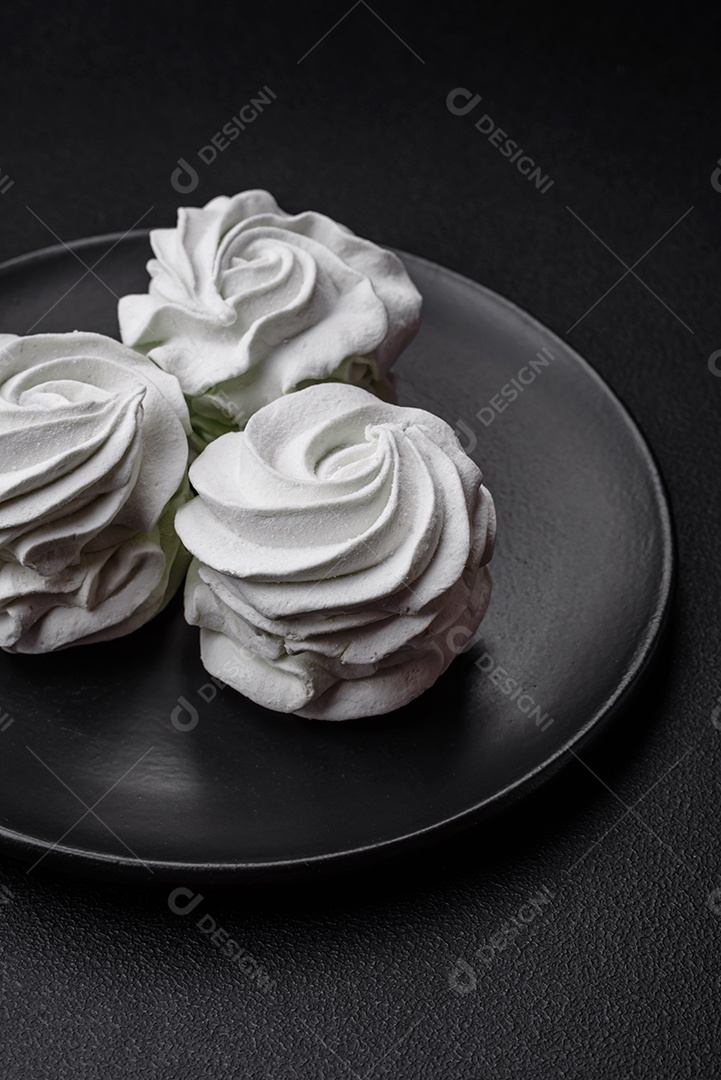 Delicioso marshmallow colorido doce em um fundo escuro de concreto. Doces saudáveis ​​para a mesa de jantar