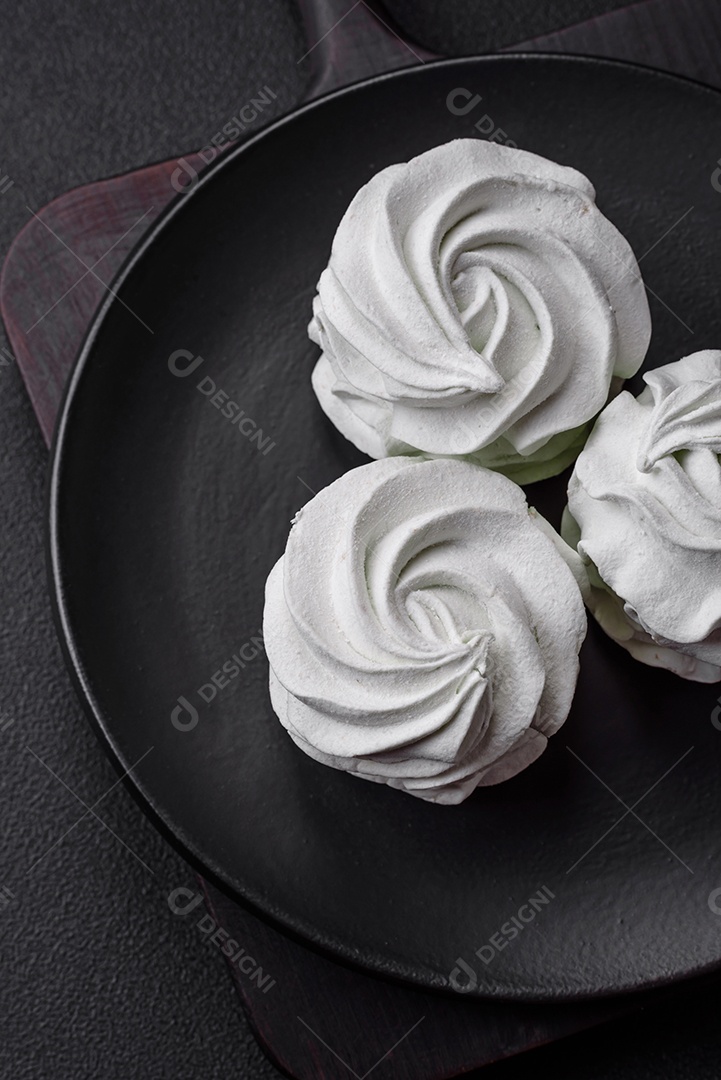 Delicioso marshmallow colorido doce em um fundo escuro de concreto. Doces saudáveis ​​para a mesa de jantar