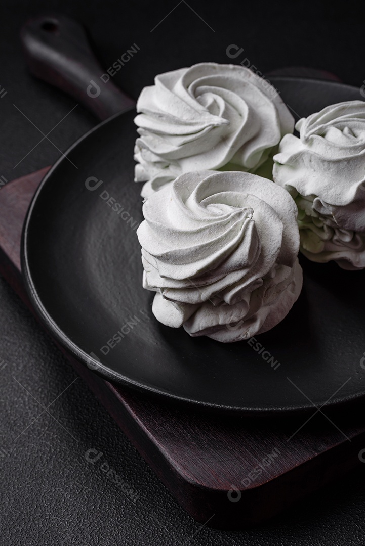 Delicioso marshmallow colorido doce em um fundo escuro de concreto. Doces saudáveis ​​para a mesa de jantar