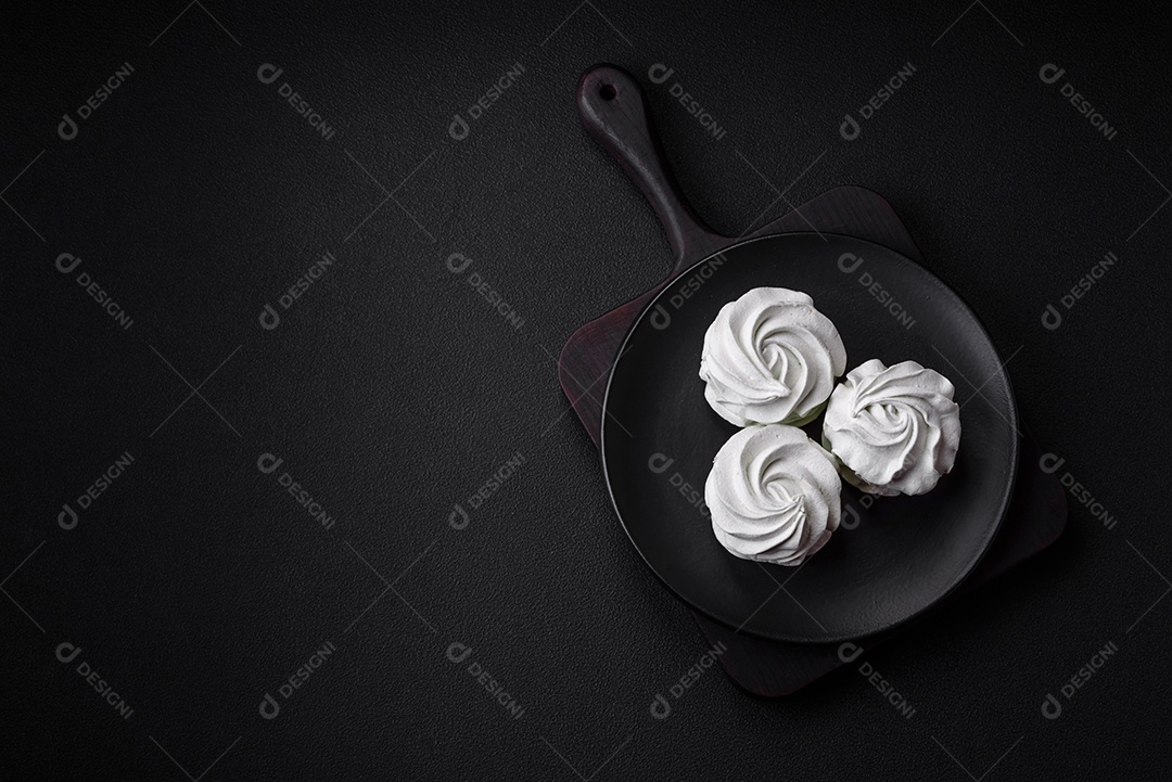 Delicioso marshmallow colorido doce em um fundo escuro de concreto. Doces saudáveis ​​para a mesa de jantar