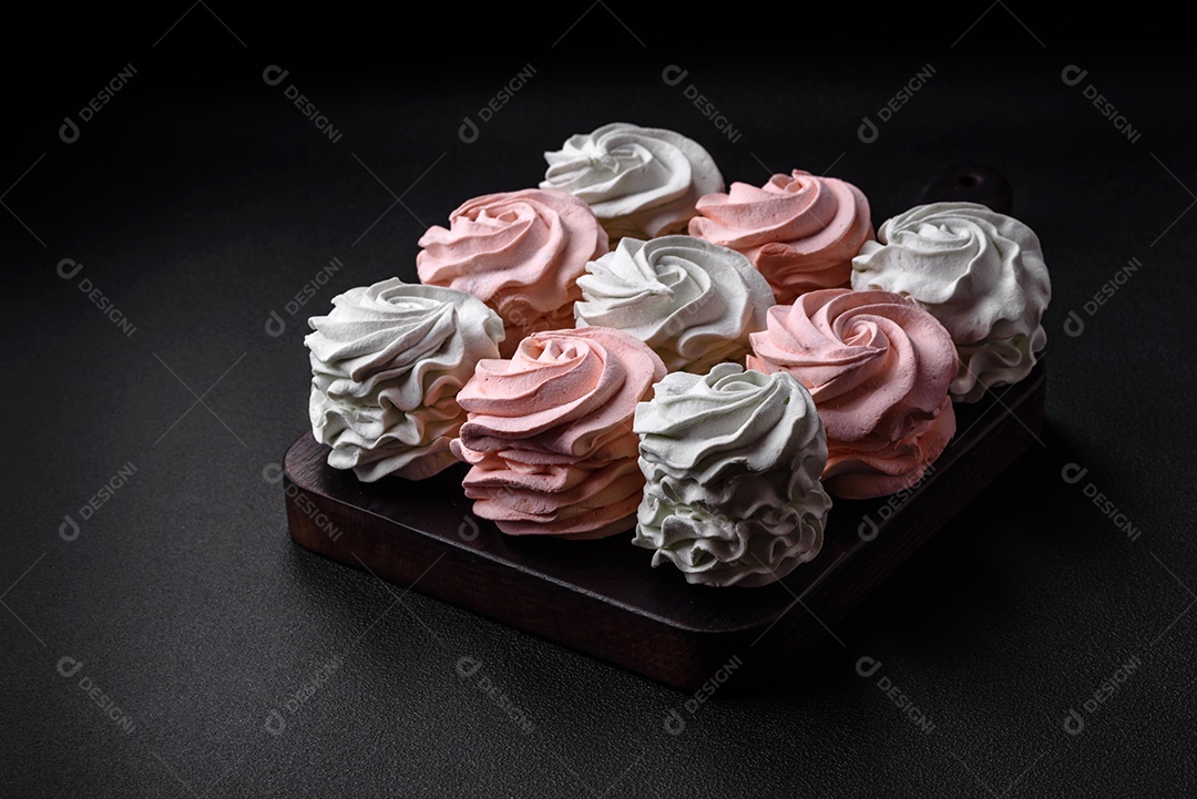 Delicioso marshmallow colorido doce em um fundo escuro de concreto. Doces saudáveis ​​para a mesa de jantar