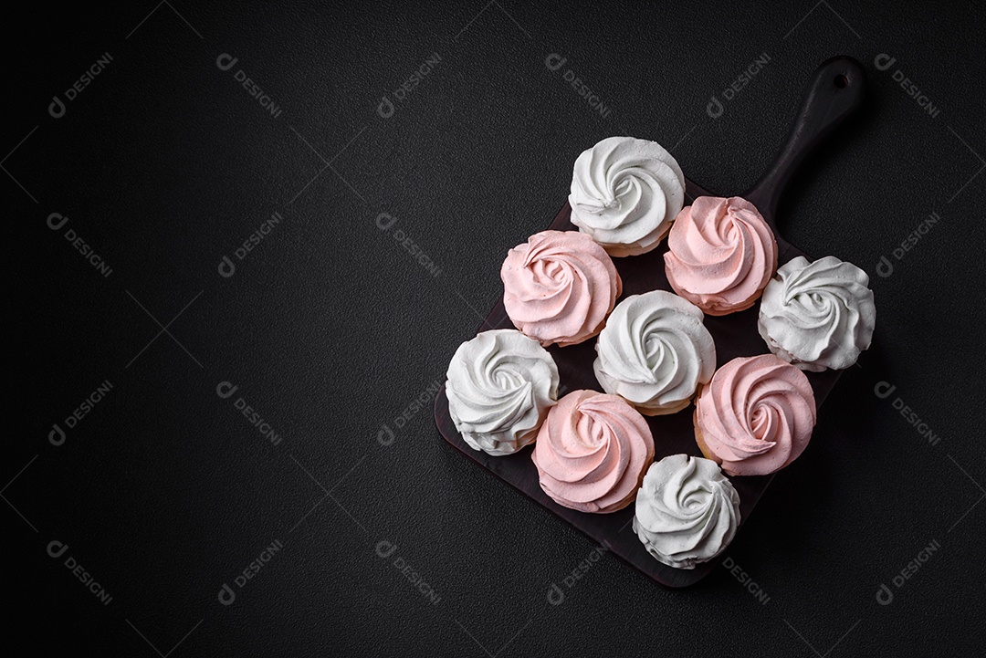 Delicioso marshmallow colorido doce em um fundo escuro de concreto. Doces saudáveis ​​para a mesa de jantar