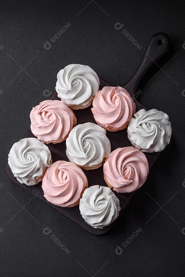 Delicioso marshmallow colorido doce em um fundo escuro de concreto. Doces saudáveis ​​para a mesa de jantar