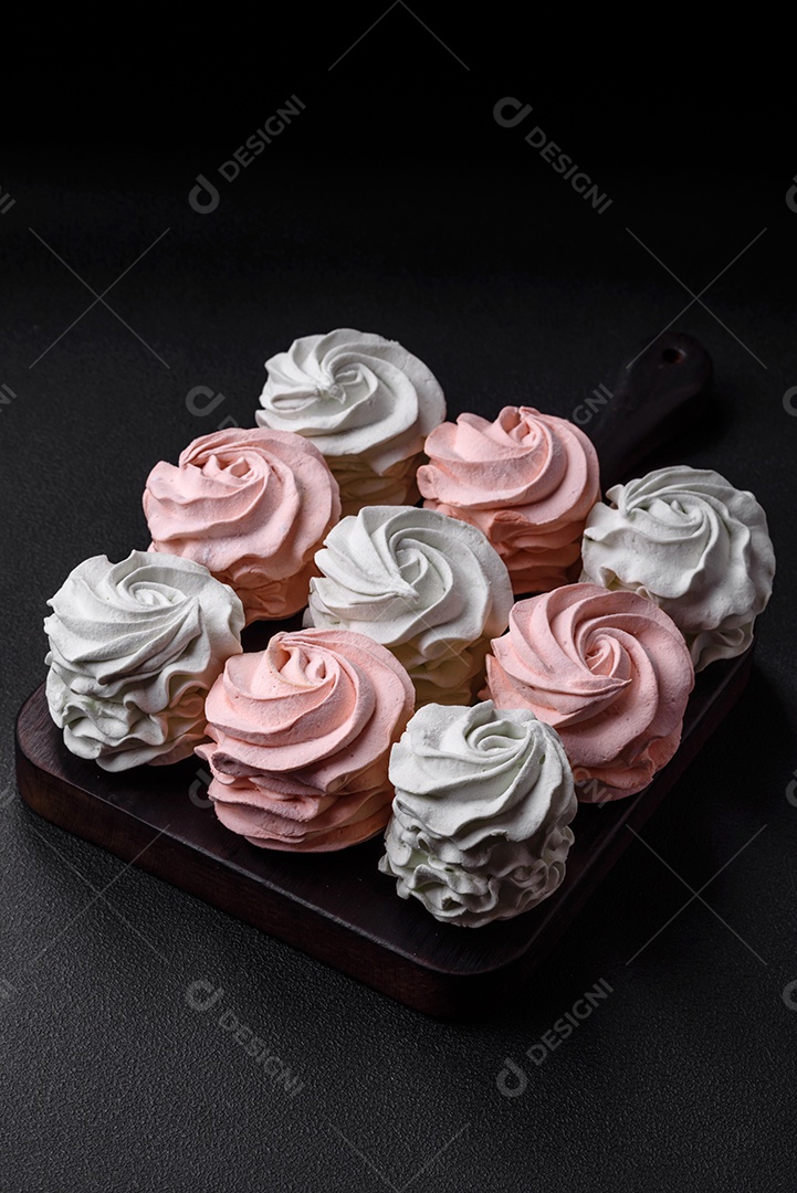 Delicioso marshmallow colorido doce em um fundo escuro de concreto. Doces saudáveis ​​para a mesa de jantar