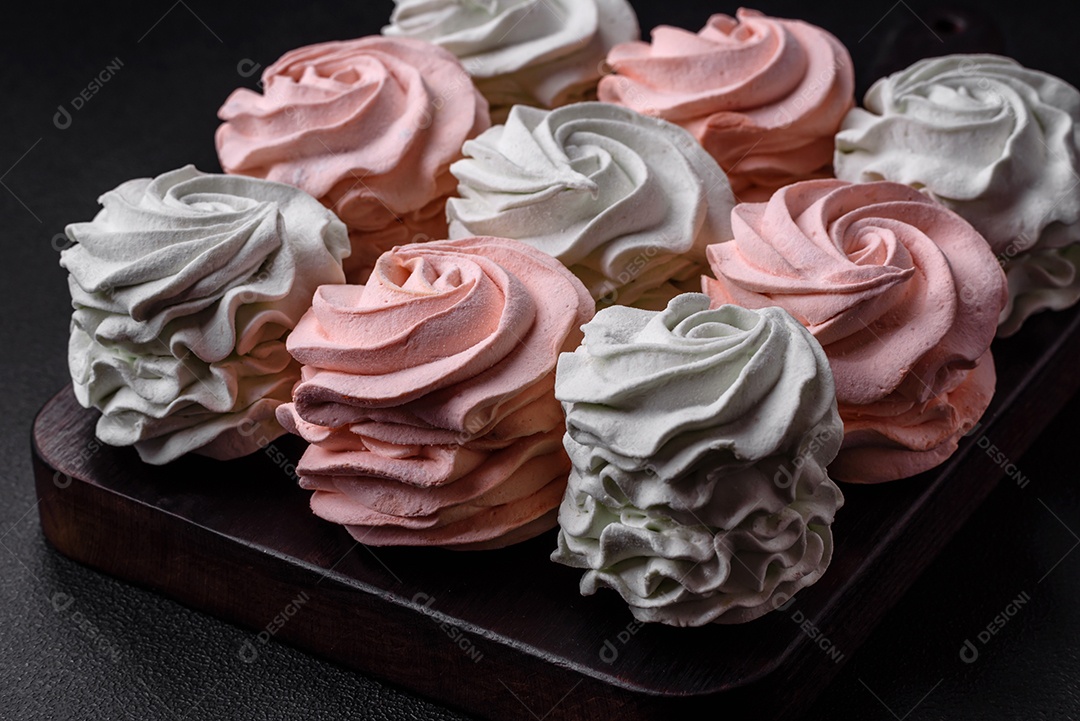 Delicioso marshmallow colorido doce em um fundo escuro de concreto. Doces saudáveis ​​para a mesa de jantar