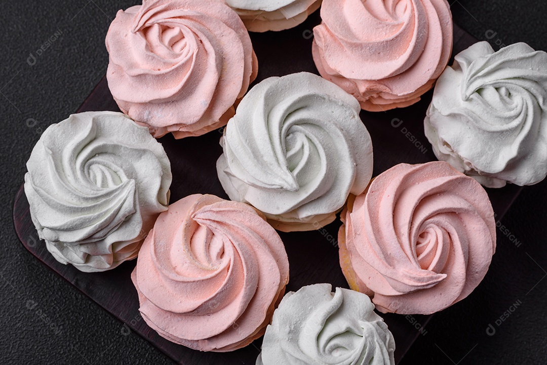 Delicioso marshmallow colorido doce em um fundo escuro de concreto. Doces saudáveis ​​para a mesa de jantar