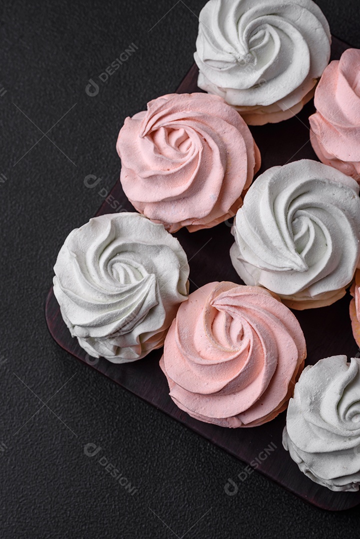 Delicioso marshmallow colorido doce em um fundo escuro de concreto. Doces saudáveis ​​para a mesa de jantar