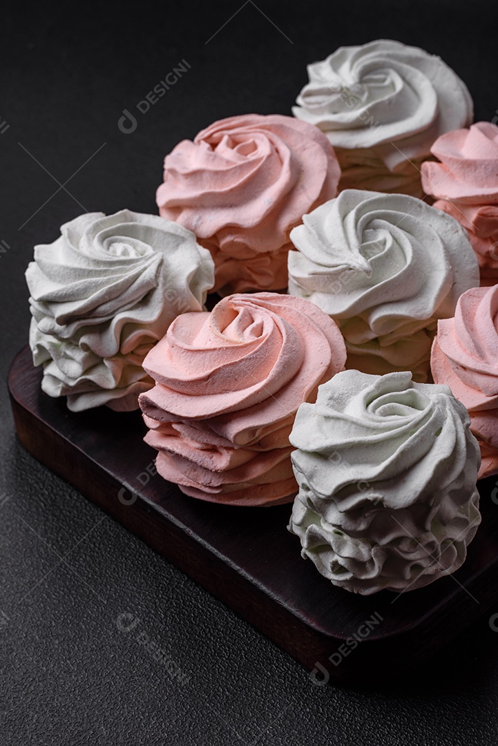 Delicioso marshmallow colorido doce em um fundo escuro de concreto. Doces saudáveis ​​para a mesa de jantar