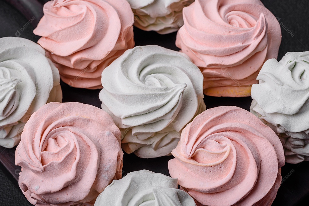 Delicioso marshmallow colorido doce em um fundo escuro de concreto. Doces saudáveis ​​para a mesa de jantar