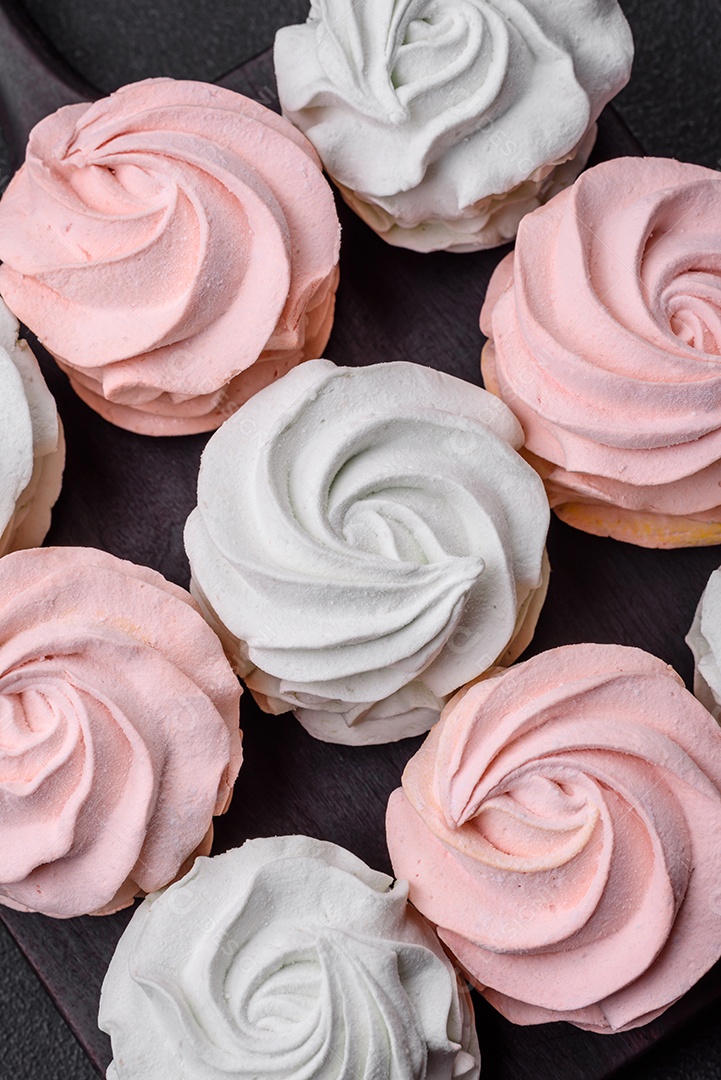 Delicioso marshmallow colorido doce em um fundo escuro de concreto. Doces saudáveis ​​para a mesa de jantar