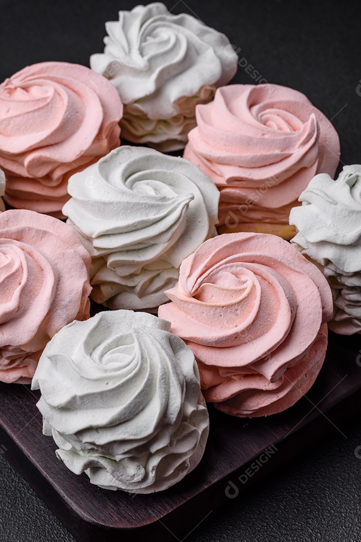 Delicioso marshmallow colorido doce em um fundo escuro de concreto. Doces saudáveis ​​para a mesa de jantar