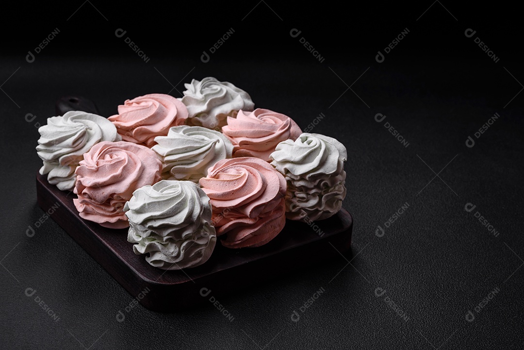 Delicioso marshmallow colorido doce em um fundo escuro de concreto. Doces saudáveis ​​para a mesa de jantar
