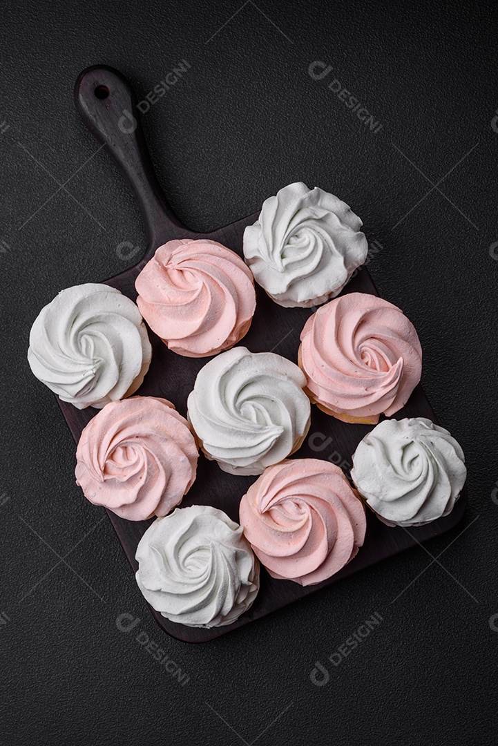 Delicioso marshmallow colorido doce em um fundo escuro de concreto. Doces saudáveis ​​para a mesa de jantar