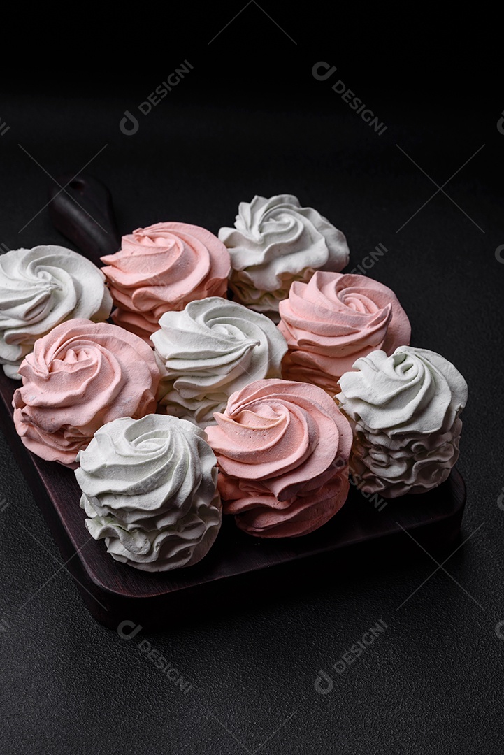 Delicioso marshmallow colorido doce em um fundo escuro de concreto. Doces saudáveis ​​para a mesa de jantar