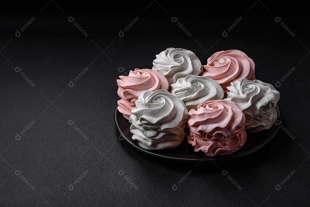 Delicioso marshmallow colorido doce em um fundo escuro de concreto. Doces saudáveis ​​para a mesa de jantar