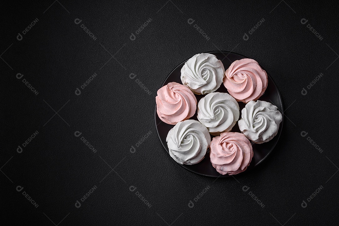 Delicioso marshmallow colorido doce em um fundo escuro de concreto. Doces saudáveis ​​para a mesa de jantar