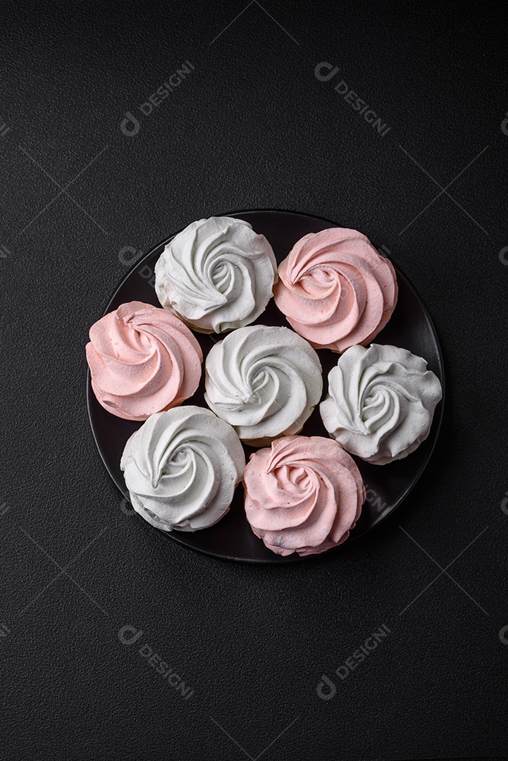 Delicioso marshmallow colorido doce em um fundo escuro de concreto. Doces saudáveis ​​para a mesa de jantar